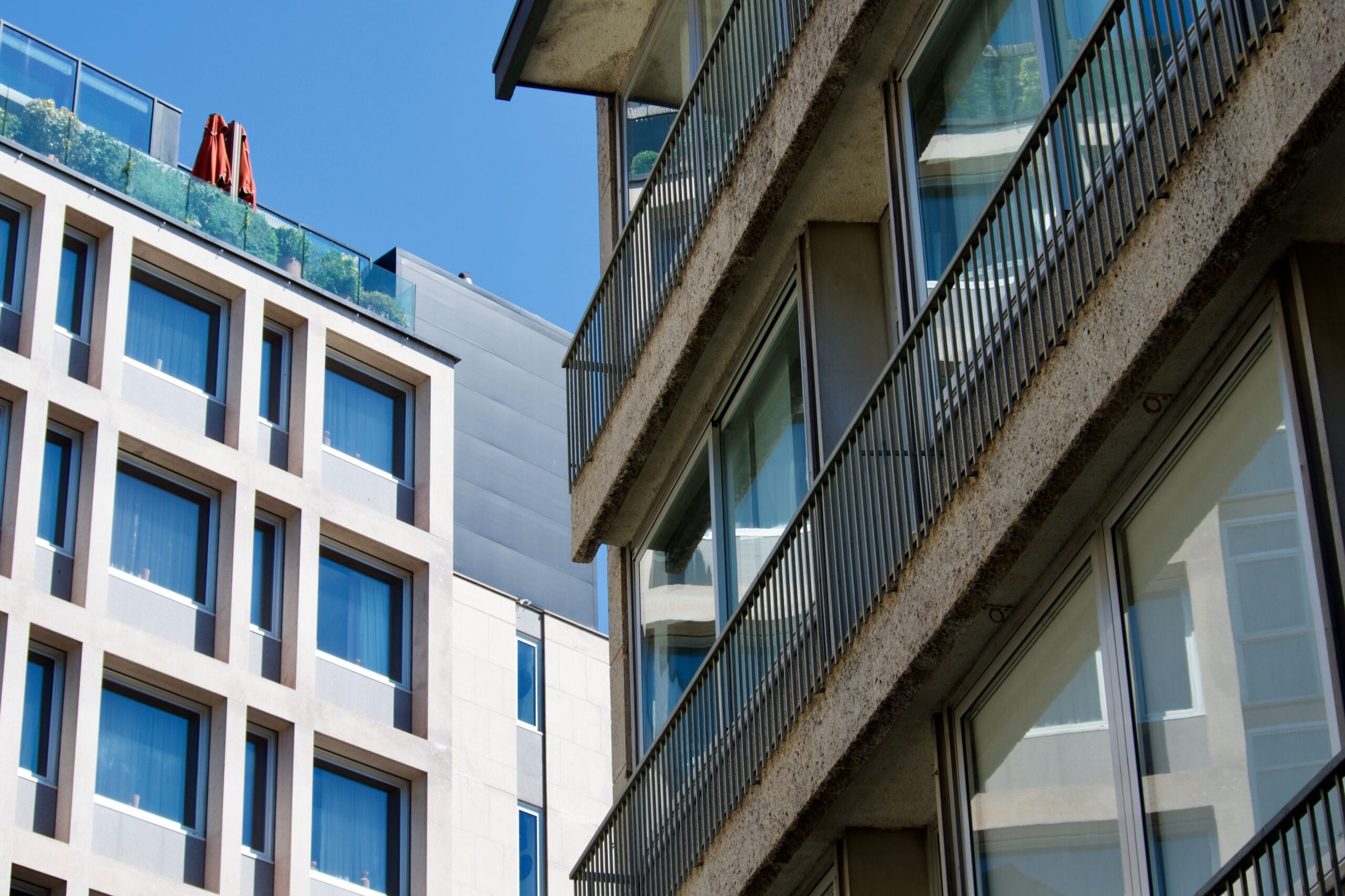 View of contemporary buildings with large windows against a blue sky.